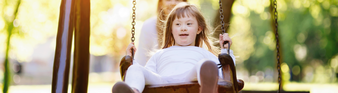 Photo of young girl with Downs Syndrome on a swing