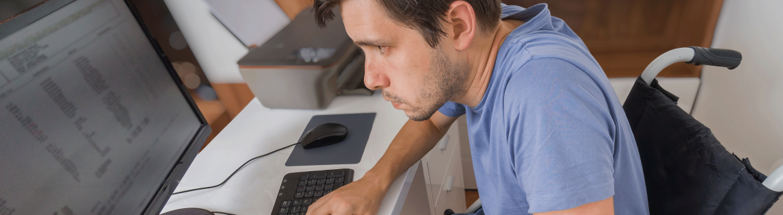 Photo of man in wheelchair using a computer