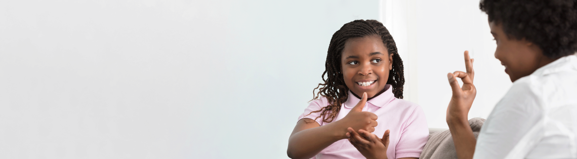 Photo of a woman and child speaking in sign language